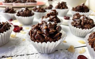 Horizontal image of mini candies in small white cupcake liners next to flaky sea salt.